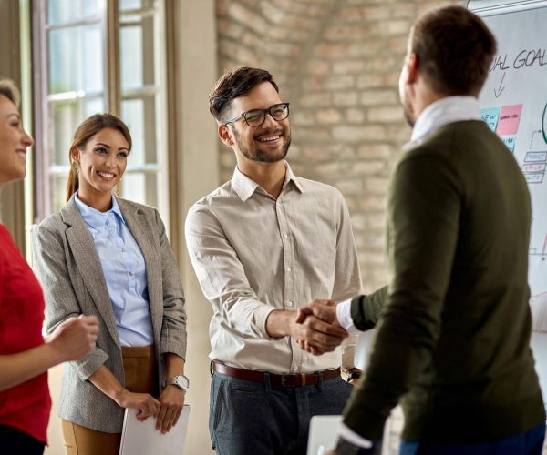 happy-coworkes-shaking-hands-after-business-presentation-office
